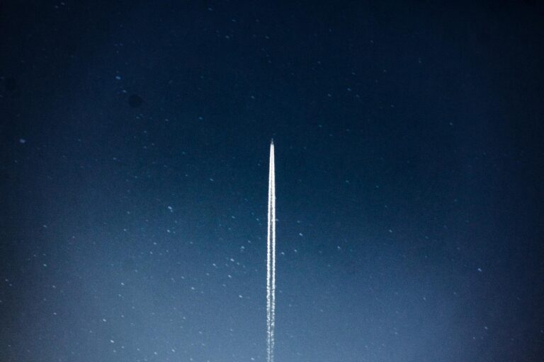 A rocket streaks through a starry night, leaving a trail in outer space.